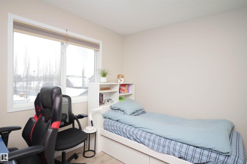 Bedroom with wood finished floors and a textured ceiling - 5836 204 Street, Edmonton, AB - Indoor Photo Showing Bedroom