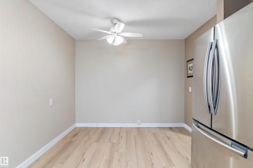 Kitchen with freestanding refrigerator, light wood finished floors, and ceiling fan - 17107 86 Avenue Nw, Edmonton, AB - Indoor Photo Showing Other Room