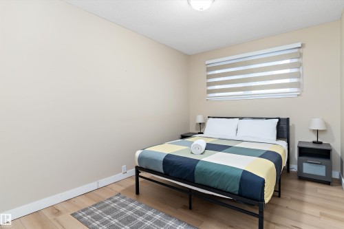 Bedroom with light wood-style flooring and a textured ceiling - 17107 86 Avenue Nw, Edmonton, AB - Indoor Photo Showing Bedroom