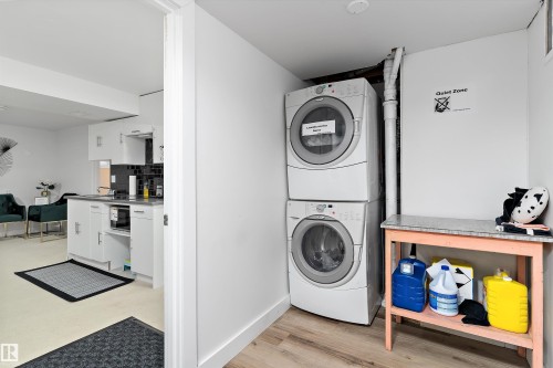 Washroom featuring stacked washer and clothes dryer and baseboards - 17107 86 Avenue Nw, Edmonton, AB - Indoor Photo Showing Laundry Room