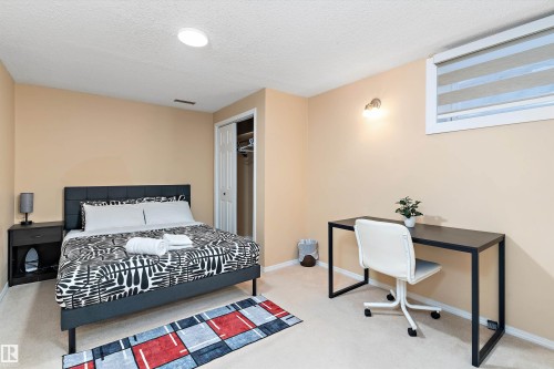Carpeted bedroom featuring a textured ceiling and a closet - 17107 86 Avenue Nw, Edmonton, AB - Indoor Photo Showing Bedroom