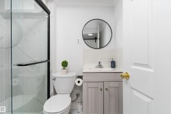Bathroom featuring vanity, backsplash, and a marble finish shower - 