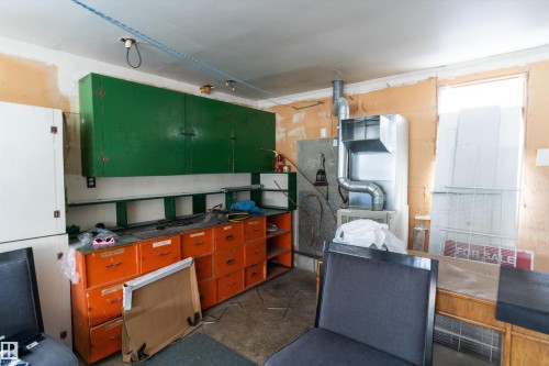 Kitchen with dark countertops, concrete flooring, and green cabinetry - 17107 86 Avenue Nw, Edmonton, AB - Indoor