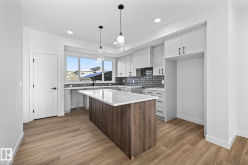 Kitchen featuring white cabinetry, a center island, decorative light fixtures, light wood finished floors, and recessed lighting - 206 Starling, Fort Saskatchewan, AB - Indoor Photo Showing Kitchen With Upgraded Kitchen