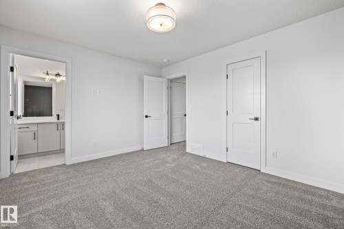 Unfurnished bedroom featuring light carpet and ensuite bath - 206 Starling, Fort Saskatchewan, AB - Indoor Photo Showing Other Room