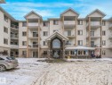 Snow covered building with a view of apartment building / complex - 210 245 Edwards Drive, Edmonton, AB  - Outdoor With Facade 