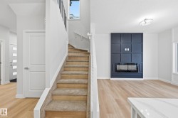 Stairway featuring a fireplace, wood finished floors, plenty of natural light, and a textured ceiling - 