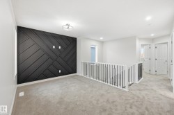Empty room featuring light carpet, recessed lighting, and an accent wall - 