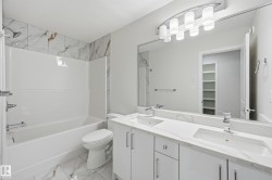 Full bathroom with light marble finish floors, shower / washtub combination, double vanity, and a walk in closet - 