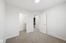 Unfurnished bedroom with a spacious closet and light colored carpet - 