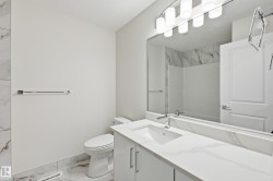 Bathroom with light marble finish floors, vanity, and a shower - 