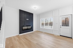 Unfurnished living room with light wood finished floors, a fireplace, a decorative wall, and stairway - 