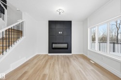 Unfurnished living room with stairway, a fireplace, and light wood-style flooring - 