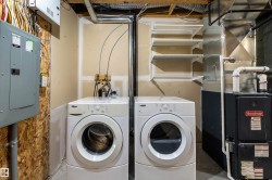 Laundry area featuring electric panel, heating unit, and washing machine and dryer - 