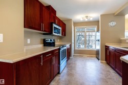 Kitchen with dark brown cabinets, appliances with stainless steel finishes, and light countertops - 
