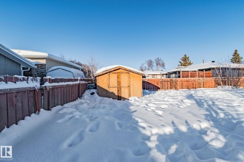 Yard covered in snow with a fenced backyard and a shed - 21 Lundy Park Road, Stony Plain, AB - Outdoor