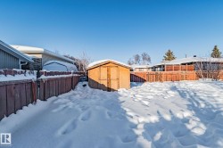 Yard covered in snow with a fenced backyard and a shed - 