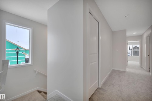 Corridor with light colored carpet and an upstairs landing - 5742 Hawthorn Common, Edmonton, AB - Indoor Photo Showing Other Room