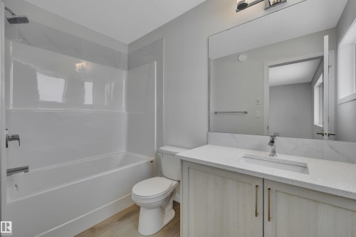 Full bath featuring bathtub / shower combination, vanity, and light wood-type flooring - 5742 Hawthorn Common, Edmonton, AB - Indoor Photo Showing Bathroom