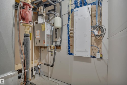 Utilities featuring electric panel, tankless water heater, and heating unit - 5742 Hawthorn Common, Edmonton, AB - Indoor Photo Showing Basement