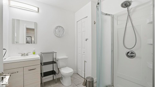 Full bath with a closet, a stall shower, vanity, and light tile patterned floors - 9831 83 Avenue, Edmonton, AB - Indoor Photo Showing Bathroom