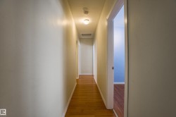 Hallway with attic access and wood finished floors - 