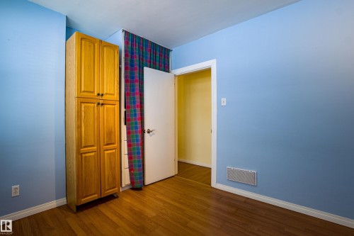 Unfurnished bedroom featuring dark wood finished floors and a closet - 9228 124A Avenue, Edmonton, AB - Indoor Photo Showing Other Room