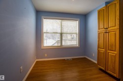 Unfurnished bedroom with dark wood finished floors and baseboards - 