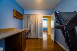 Hallway featuring dark wood finished floors and baseboards - 