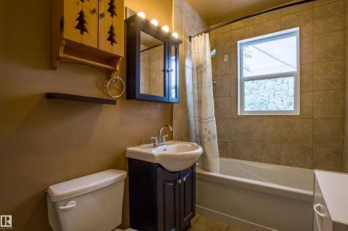 Full bath featuring vanity, shower / tub combo with curtain, and tile patterned floors - 9228 124A Avenue, Edmonton, AB - Indoor Photo Showing Bathroom