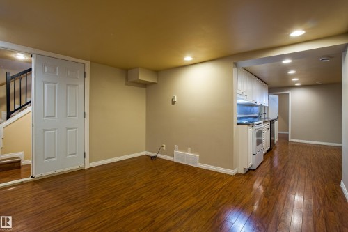 Below grade area with stairs, dark wood-style flooring, and recessed lighting - 9228 124A Avenue, Edmonton, AB - Indoor