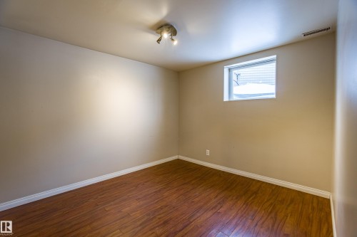 Empty room featuring wood-type flooring and baseboards - 9228 124A Avenue, Edmonton, AB - Indoor Photo Showing Other Room
