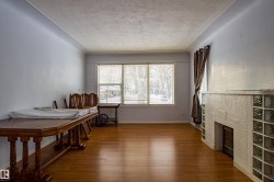 Sitting room with a textured ceiling, wood finished floors, and a fireplace - 