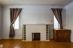 Unfurnished living room featuring a fireplace, wood finished floors, and a textured ceiling - 