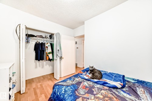 Bedroom with a textured ceiling, light wood-style flooring, and a closet - 15515 92A Avenue, Edmonton, AB - Indoor Photo Showing Bedroom