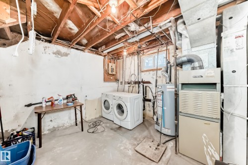 Below grade area with water heater, heating unit, independent washer and dryer, and electric panel - 15515 92A Avenue, Edmonton, AB - Indoor Photo Showing Laundry Room