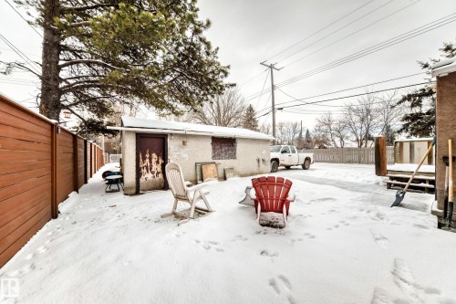 Snow covered rear of property with a fenced backyard and stucco siding - 15515 92A Avenue, Edmonton, AB - Outdoor