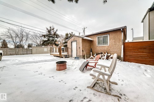Snow covered back of property with stucco siding and a wooden deck - 15515 92A Avenue, Edmonton, AB - Outdoor