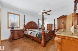 Bedroom with dark wood-type flooring, a ceiling fan, and a textured ceiling - 