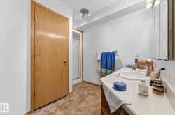 Full bathroom featuring a shower stall, vanity, a textured ceiling, and stone finish flooring - 