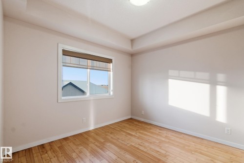 Spare room featuring baseboards and light wood-style floors - 405 9517 160 Avenue, Edmonton, AB - Indoor Photo Showing Other Room