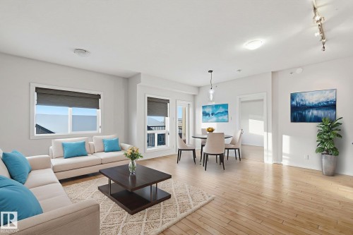 Living room featuring track lighting, light wood-style floors, and plenty of natural light - 405 9517 160 Avenue, Edmonton, AB - Indoor Photo Showing Living Room