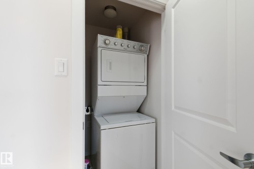 Laundry room with stacked washer and clothes dryer - 405 9517 160 Avenue, Edmonton, AB - Indoor Photo Showing Laundry Room
