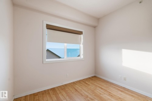Spare room featuring baseboards and hardwood / wood-style floors - 405 9517 160 Avenue, Edmonton, AB - Indoor Photo Showing Other Room