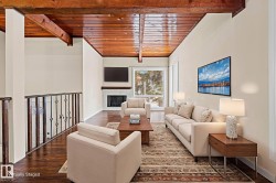 Living area with wooden ceiling, a fireplace, and wood finished floors - 