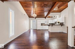 Unfurnished living room featuring wooden ceiling and dark wood-type flooring - 