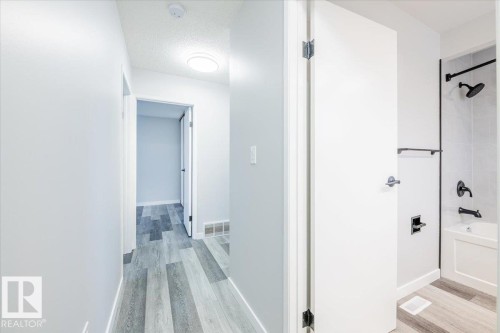 Hall with light wood-type flooring and a textured ceiling - 17808 76 Avenue, Edmonton, AB - Indoor Photo Showing Other Room