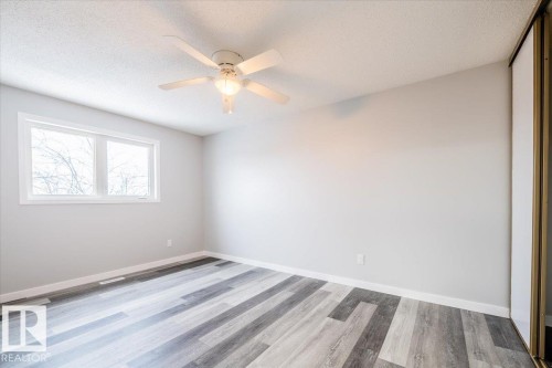 Spare room featuring a textured ceiling, light wood-style flooring, and ceiling fan - 17808 76 Avenue, Edmonton, AB - Indoor Photo Showing Other Room