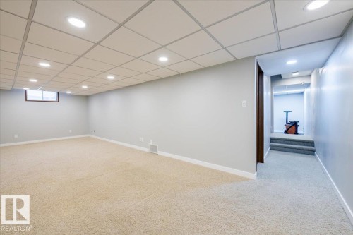 Below grade area featuring light carpet, a drop ceiling, and recessed lighting - 17808 76 Avenue, Edmonton, AB - Indoor