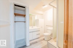Full bathroom featuring vanity, a stall shower, and light wood finished floors - 